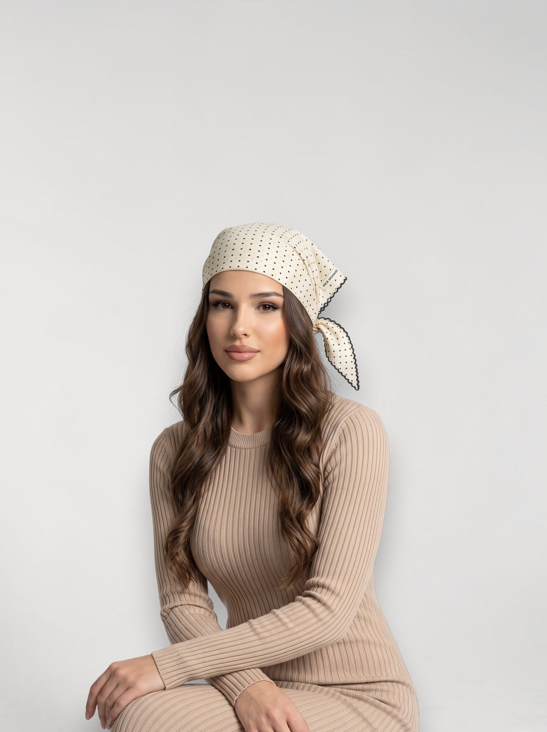 Brisconti Portofino Dreieckschal mit Punkten als Haarband getragen, kombiniert mit einem beigen Rippstrickkleid.