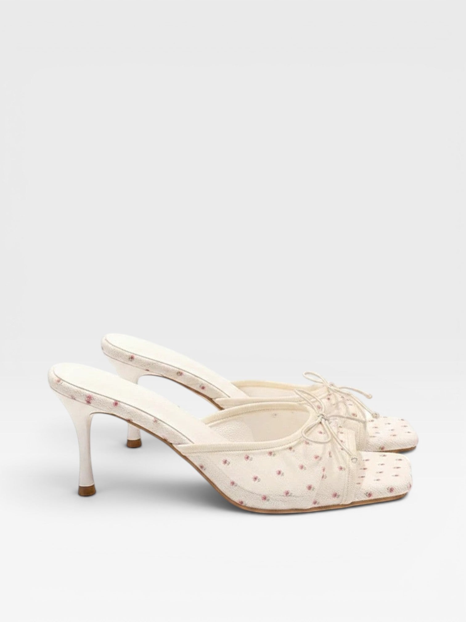 Brisconti Portofino Mules in Creme mit floralem Muster, kleiner Schleife und elegantem 7 cm Stiletto-Absatz.